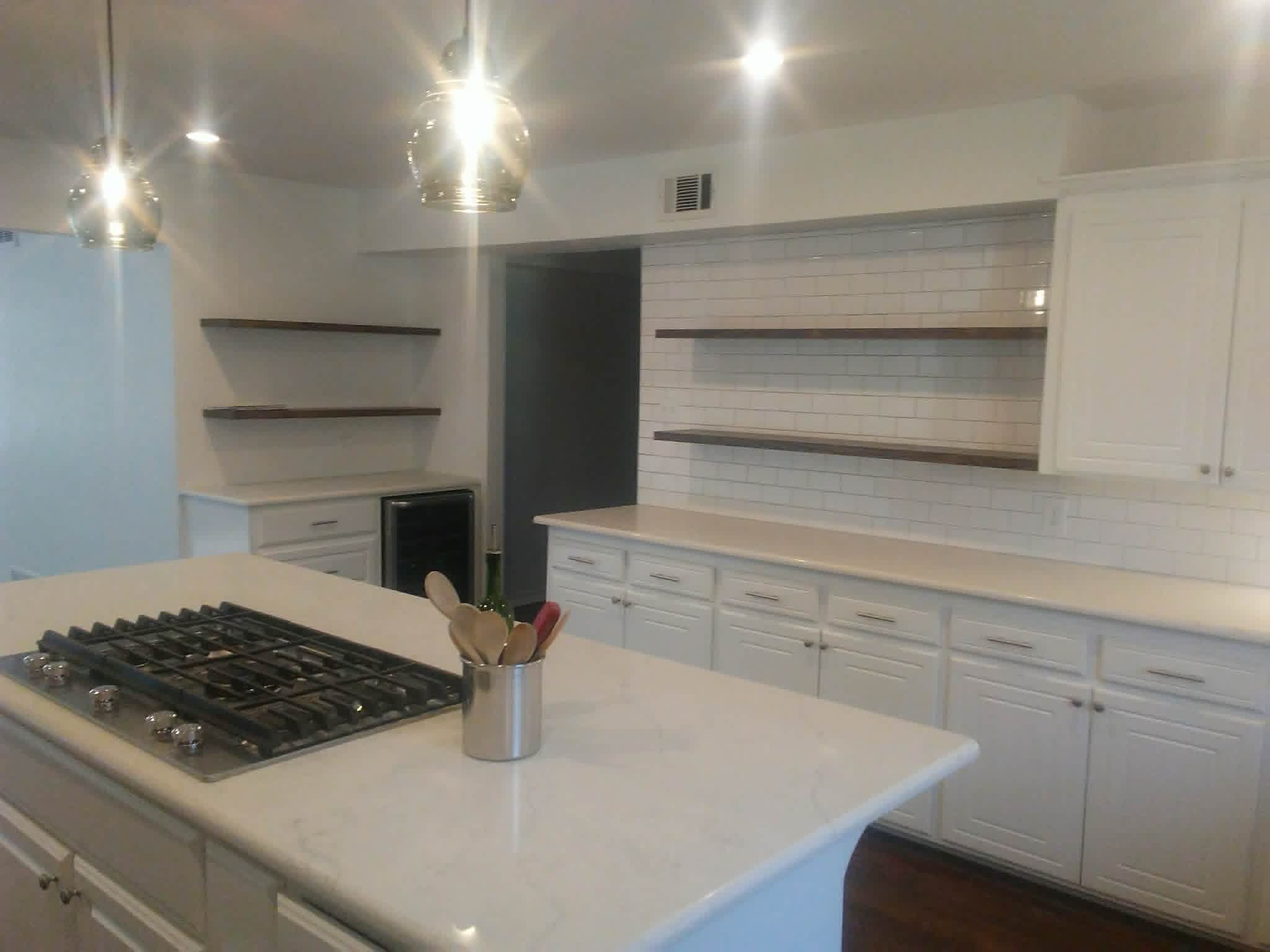 Kitchen island detail with cooktop and floating shelves
